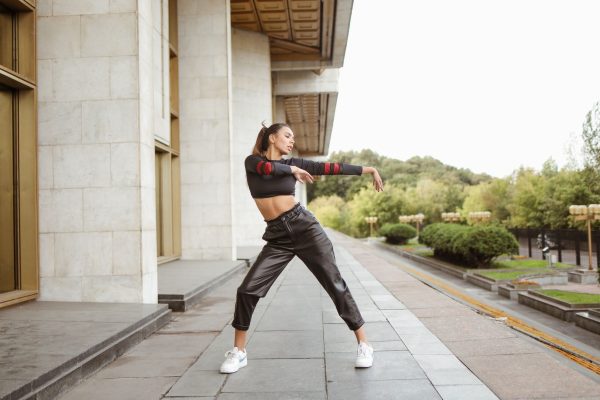 Person styling black cargo trip pants with chains and alternative streetwear accessories demonstrating styling guide techniques