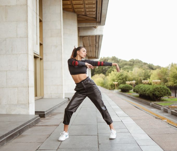 Person styling black cargo trip pants with chains and alternative streetwear accessories demonstrating styling guide techniques
